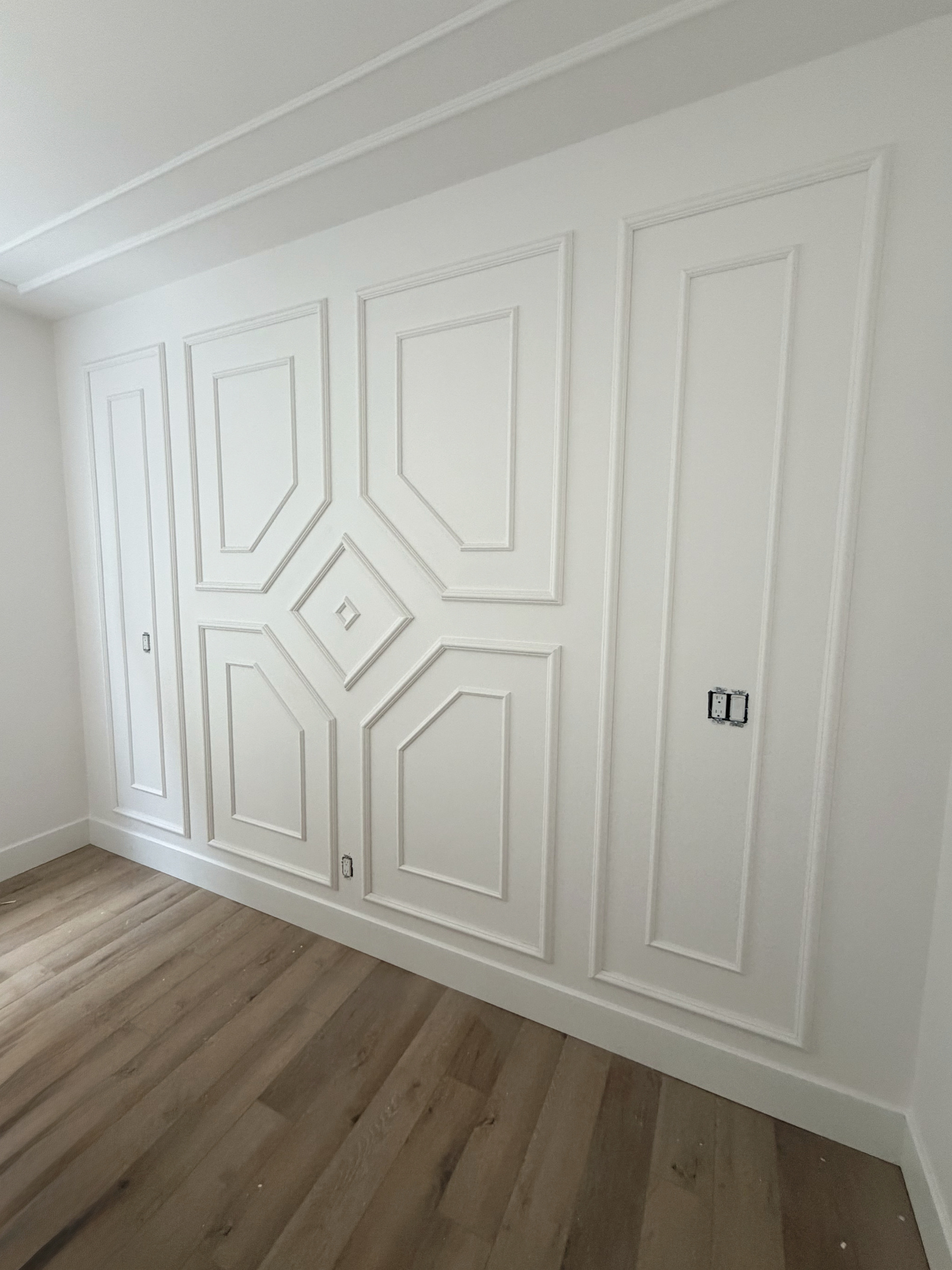 White geometric feature wall created with decorative trim profiles