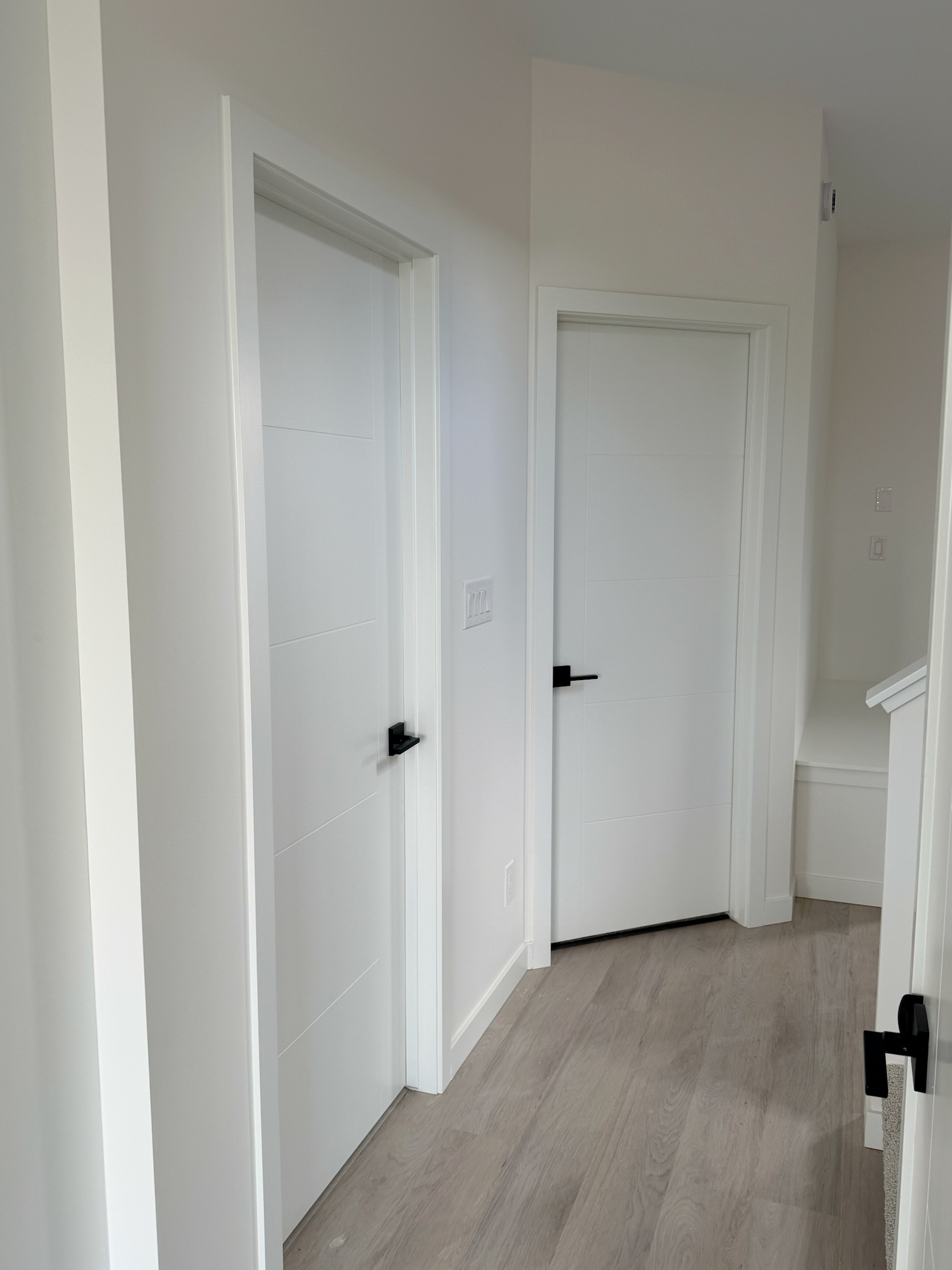Multiple white interior doors with clean casing and black hardware