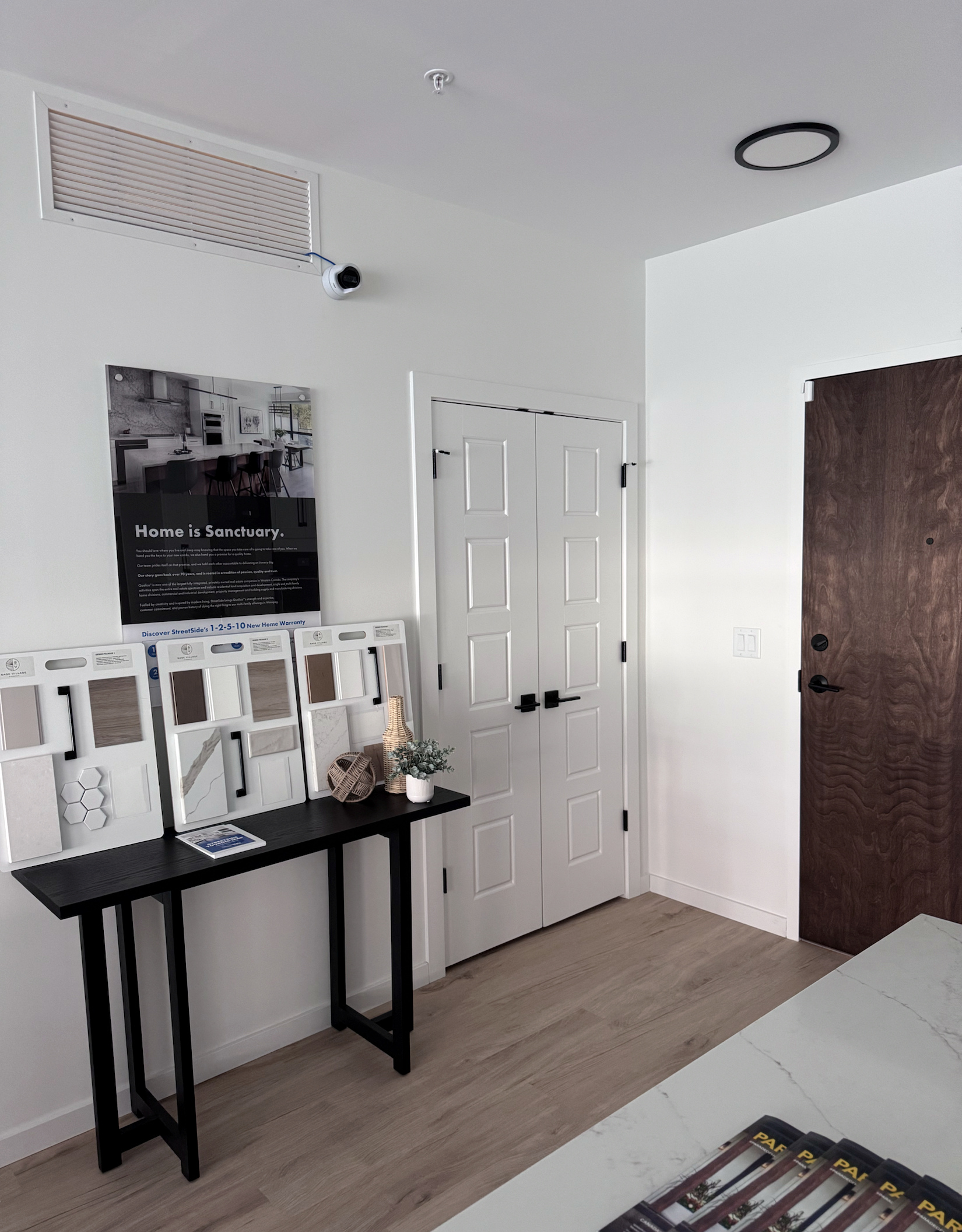 Paired white panel doors and a stained wood entry door in a finished interior