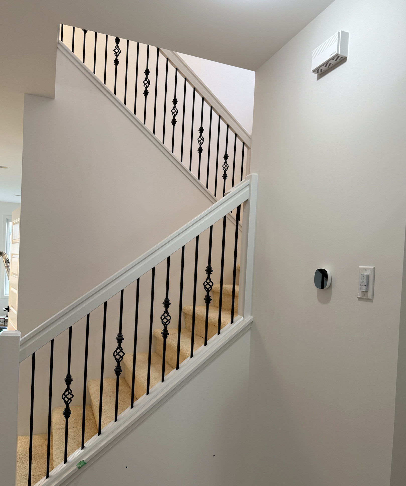 White stair rail with decorative black metal balusters