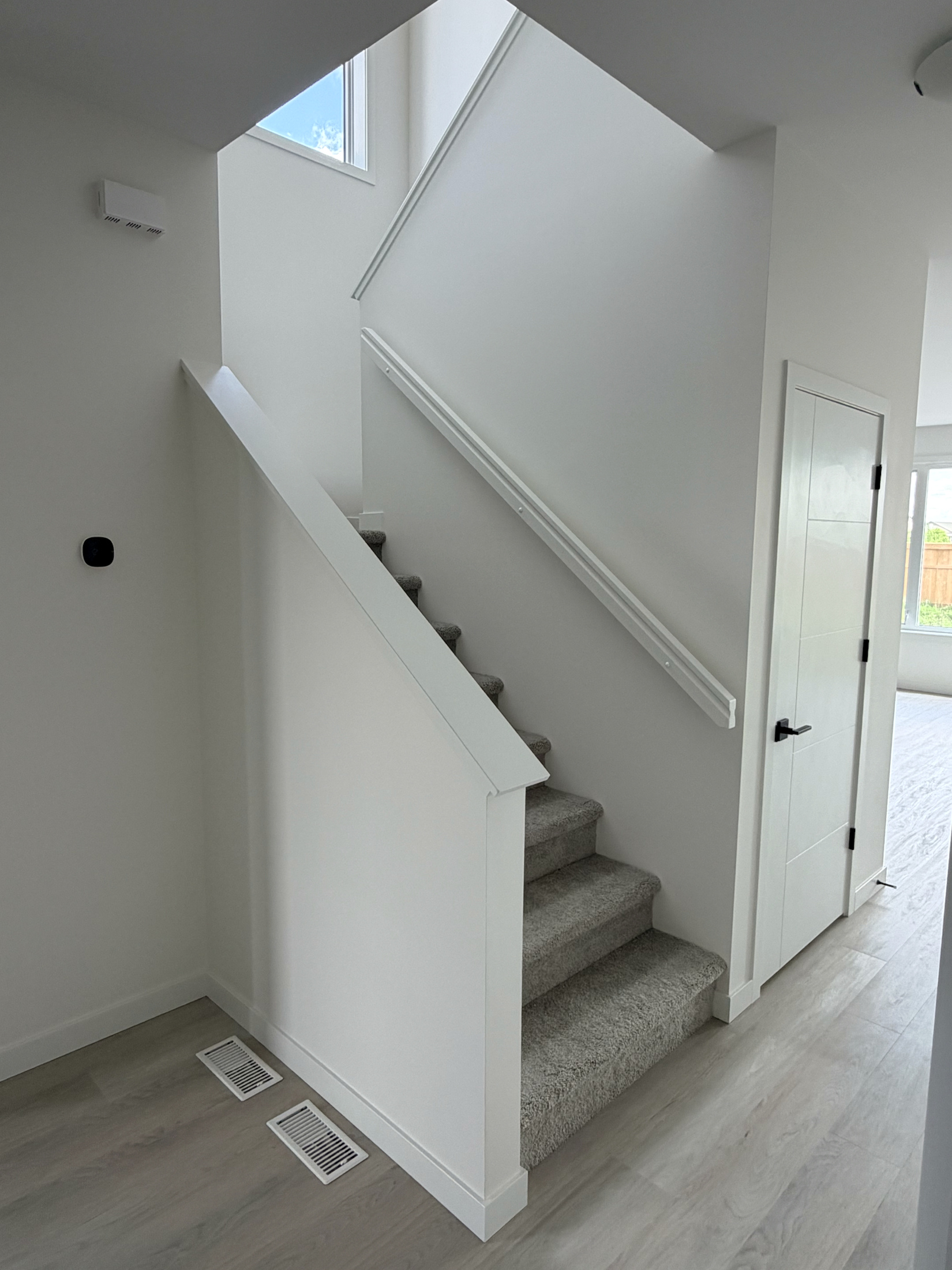 Interior stair handrail, wall trim, and adjacent door casing