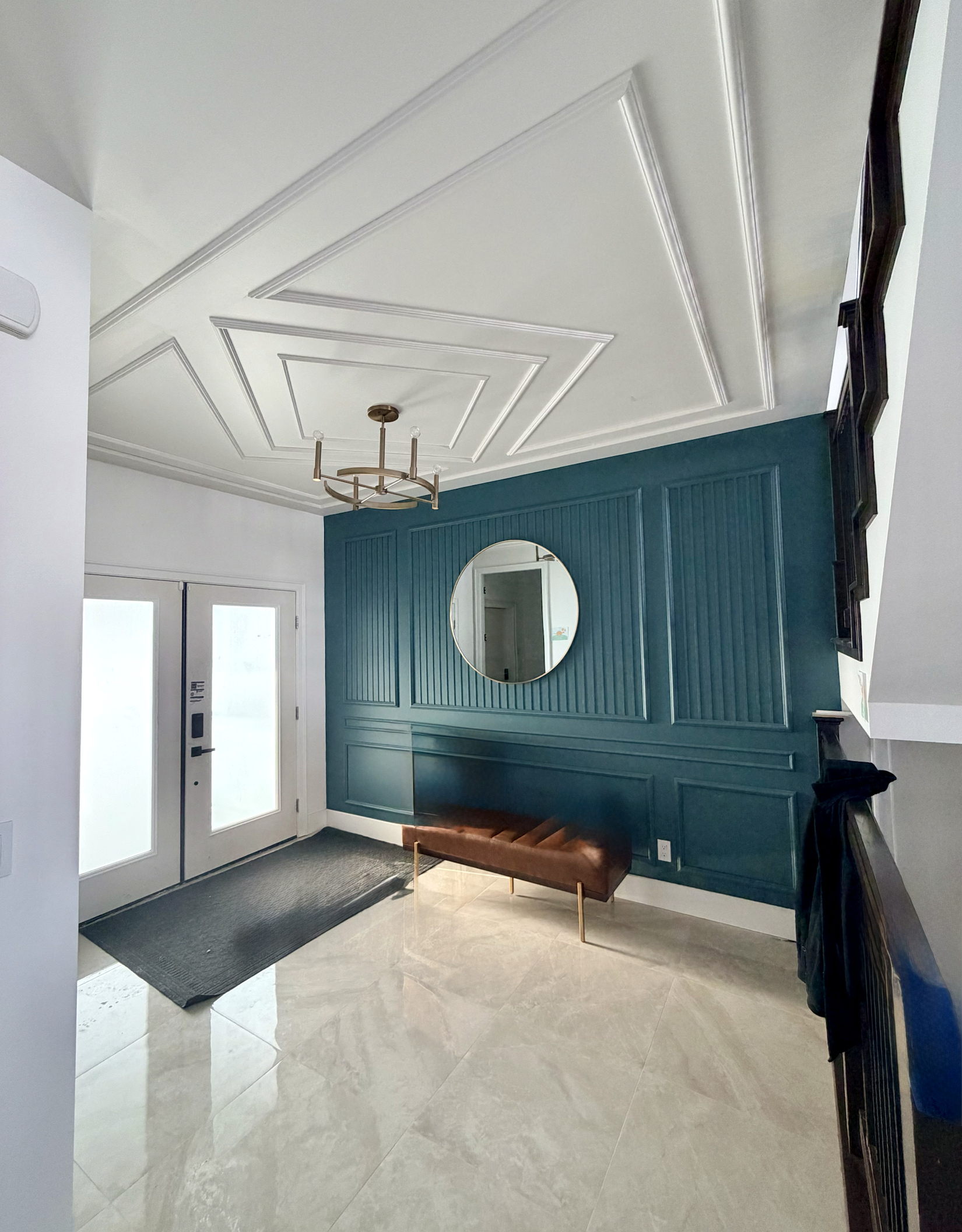 Teal architectural feature wall with detailed ceiling moulding installed by Nand Finishing