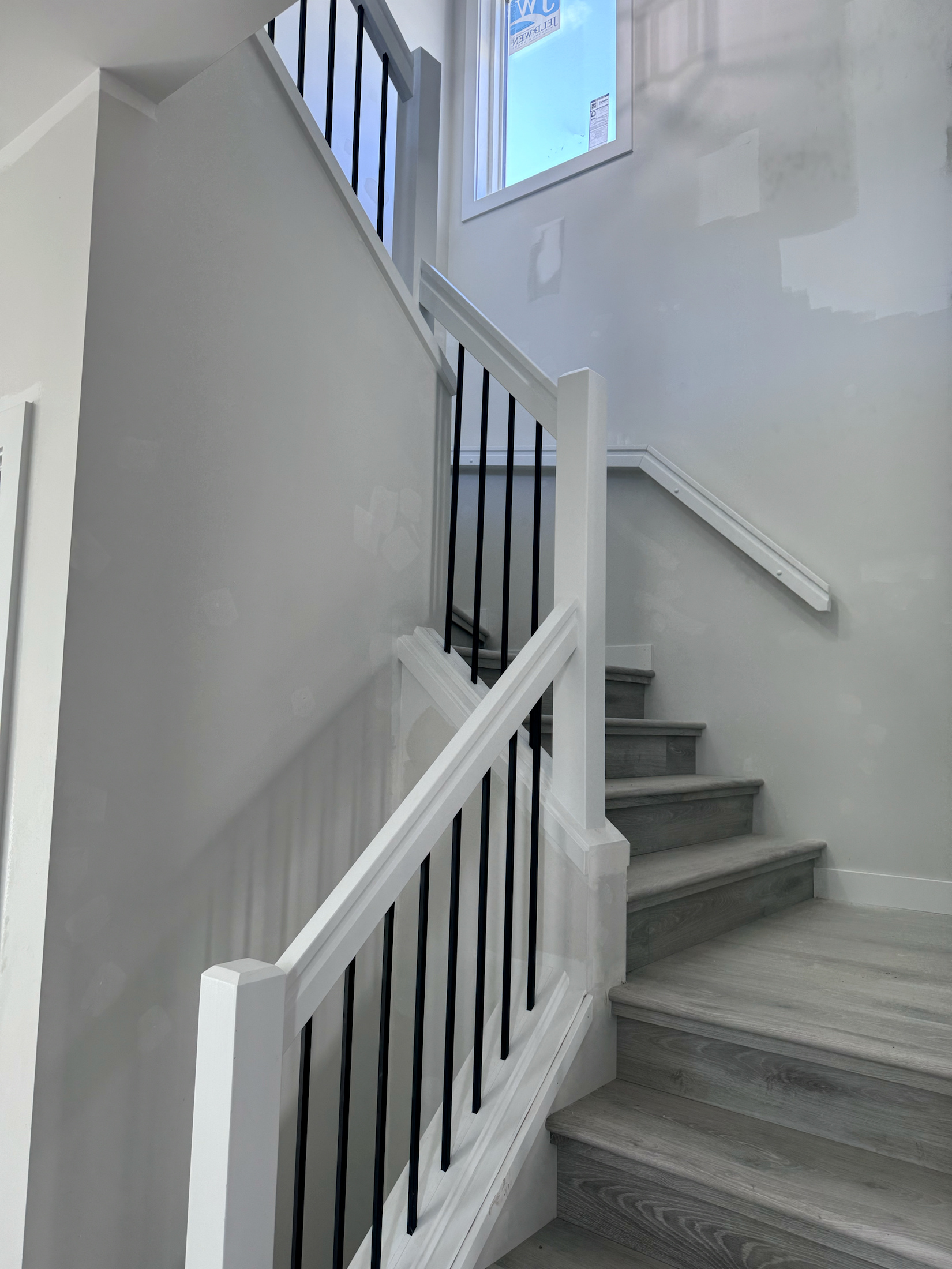 White stair railing and trim with slim black balusters